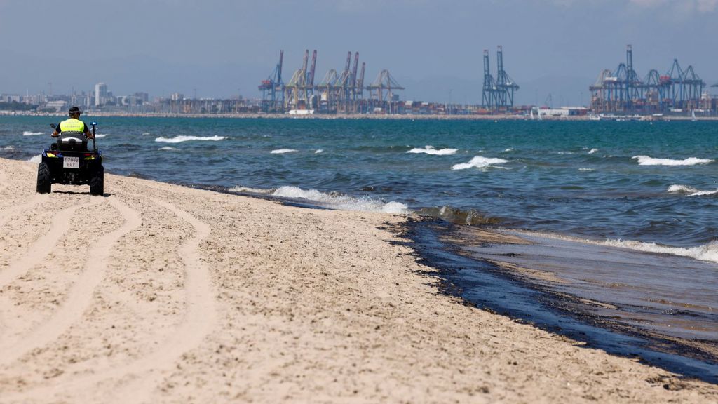 Un agente de la Policía Local recorre la playa afectada por el vertido de combustible, que según las primeras estimaciones mide entre 1,5 y dos kilómetros, y que ha obligado a prohibir el baño en las playas de l'Arbre del Gos y El Saler
