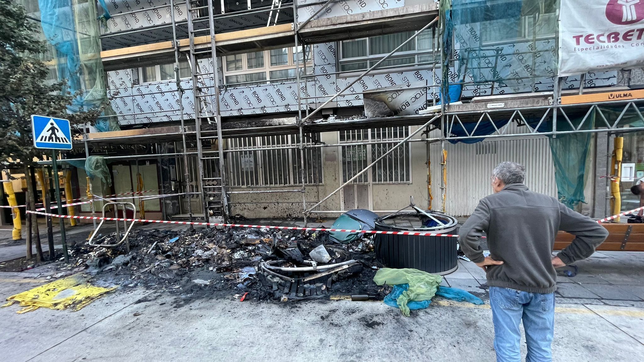 Un vecino de A Coruña observa con impotencia lo que ha quedado tras el incendio de un contenedor