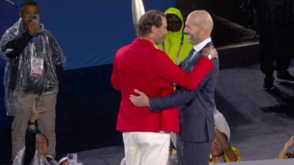 Rafa Nadal y Zinedine Zidane se abrazan en el relevo del pebetero