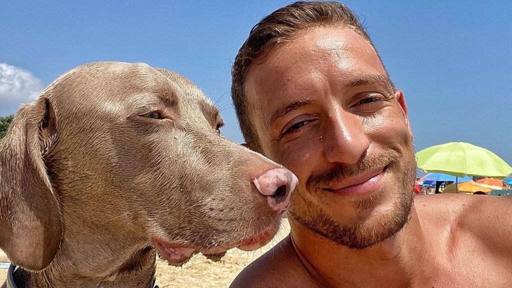 Rubén Torres posando junto a su mascota en la playa