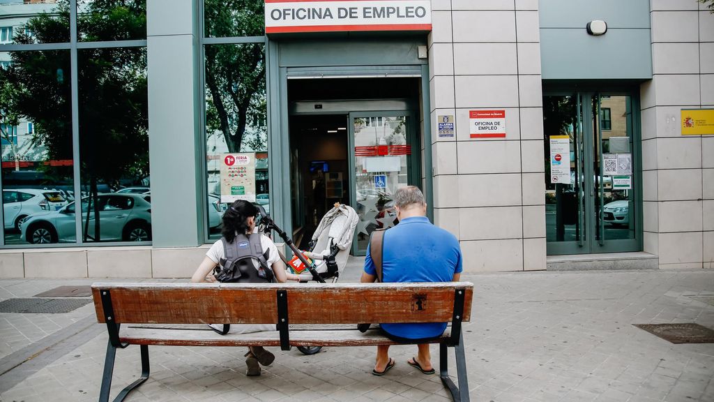 Archivo - Dos personas esperan fuera de una oficina de empleo de Madrid