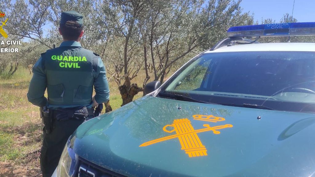 Archivo - Agente de la Guardia Civil junto a su coche.