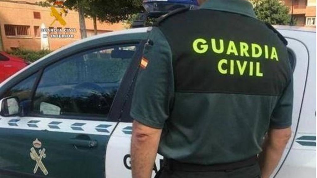 Un agente y un coche de la Guardia Civil.