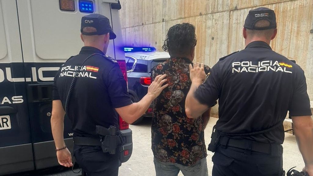 Dos agentes conducen detenido al hombre acusado de agredir a su pareja en una discoteca de Ibiza