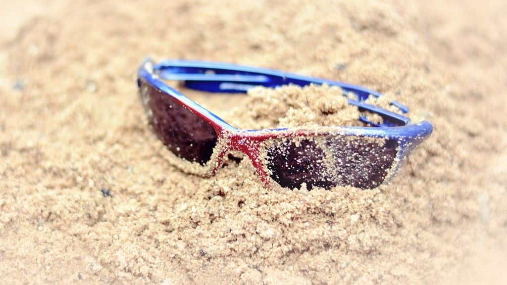 Gafas de sol en la arena de la playa