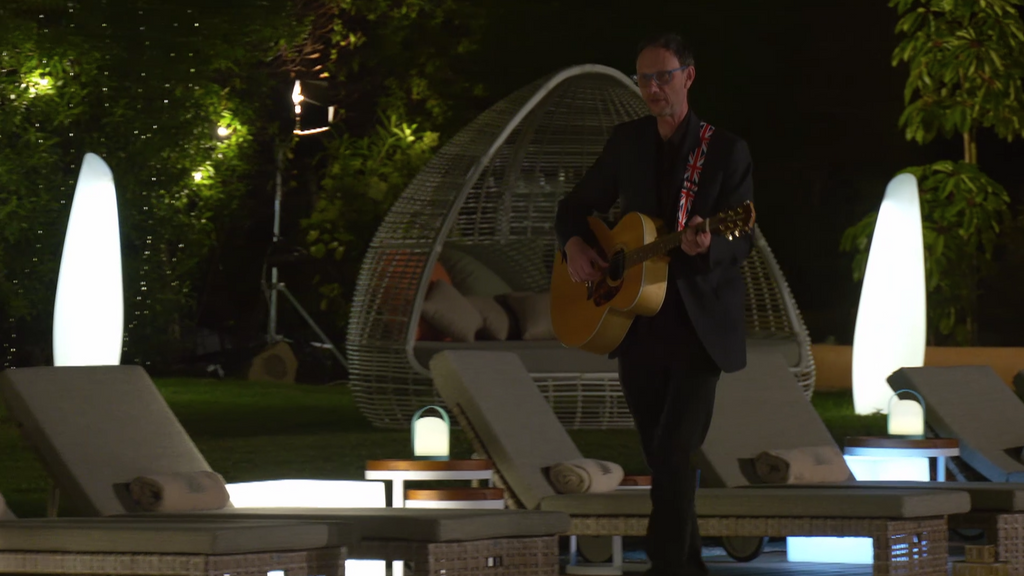 Simon, guitarra en mano, le prepara una sorpresa a su cita