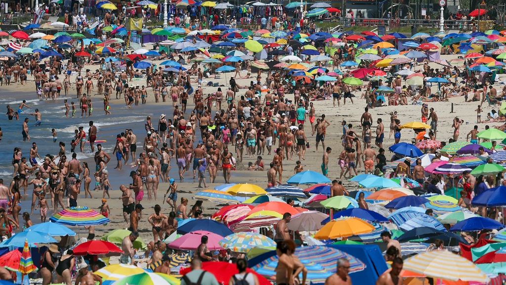 Playa llena de gente en el puente de agosto