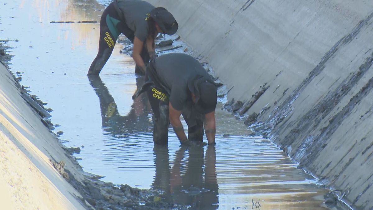 Dos agentes de la Guardia Civil rastean palmo a palmo un canal en Mocejón