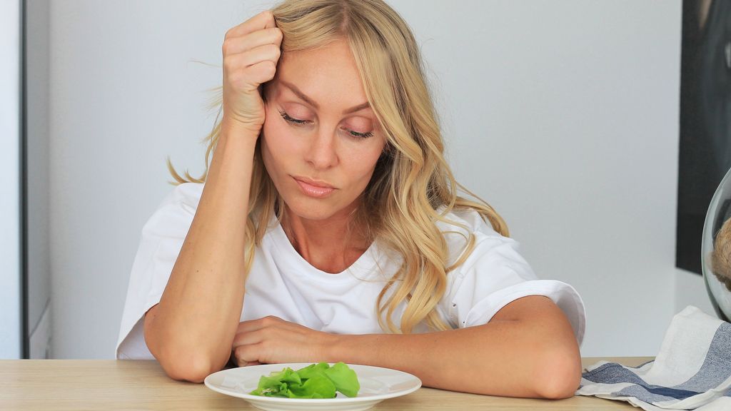 Una mujer pasando hambre con una unidad de hoja de lechuga