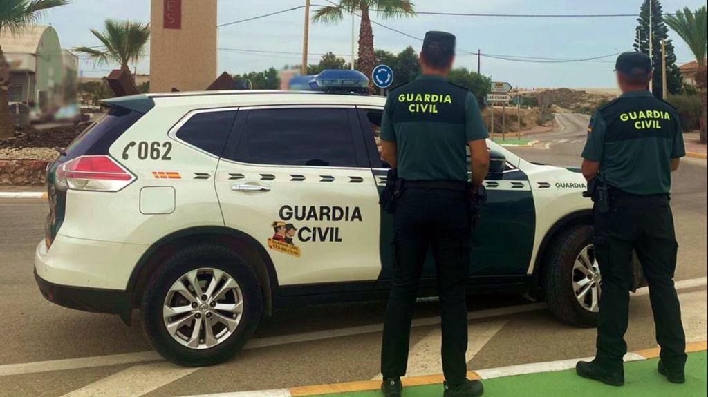 Agentes de la Guardia Civil con coche patrulla