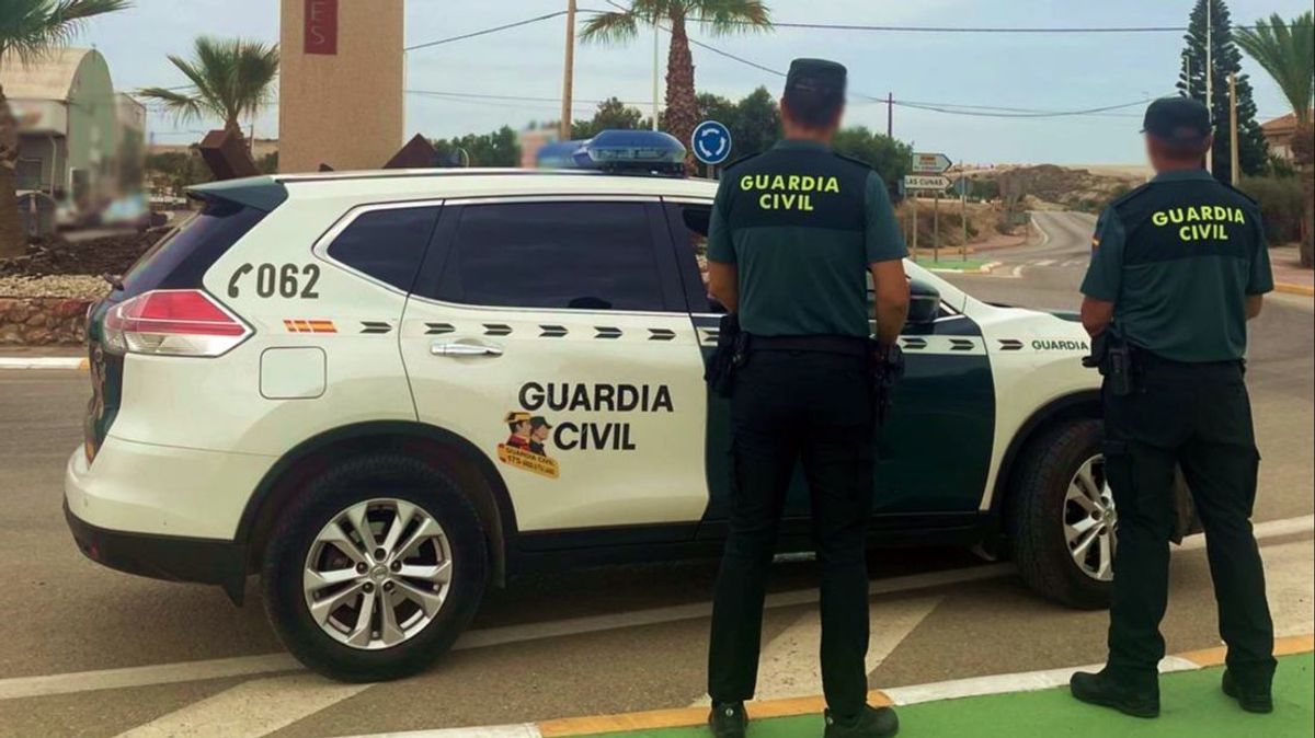 Agentes de la Guardia Civil con coche patrulla