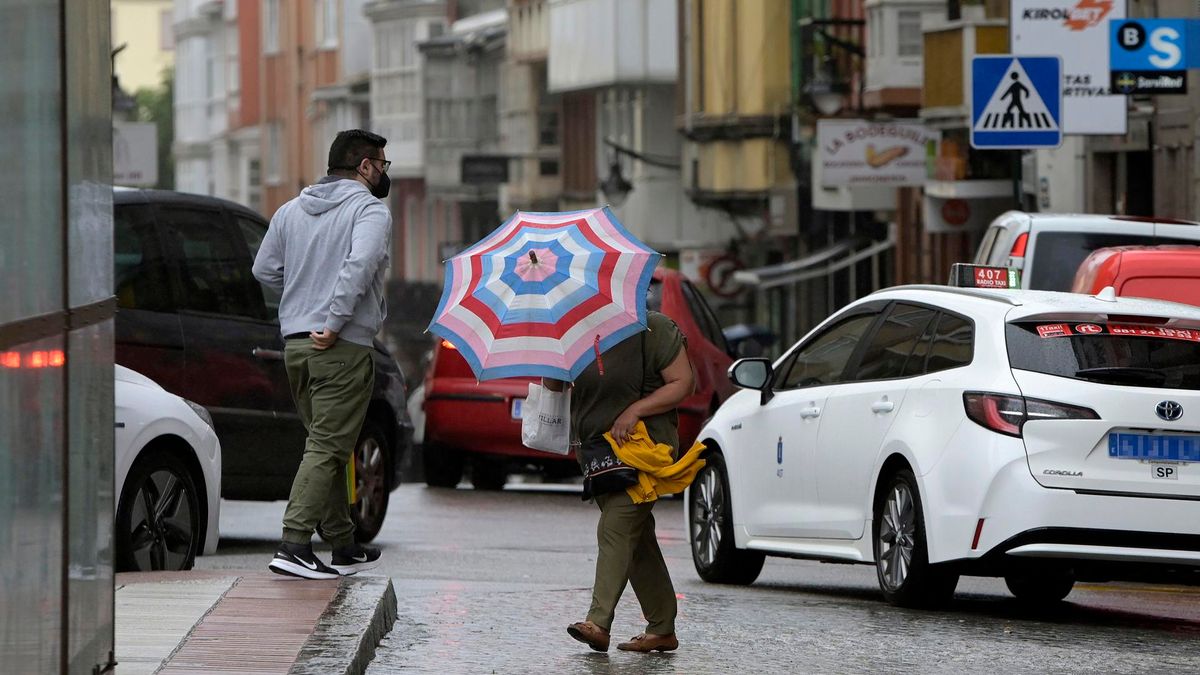 Archivo - Una mujer se resguarda del viento y la lluvia con un paraguas en el centro de la ciudad, a 19 de junio de 2022, en A Coruña, Galicia, (España).