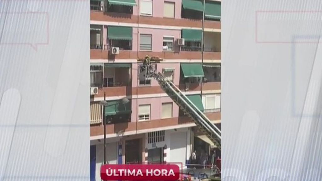 Los bomberos sacando a la víctima por la ventana de su vivienda