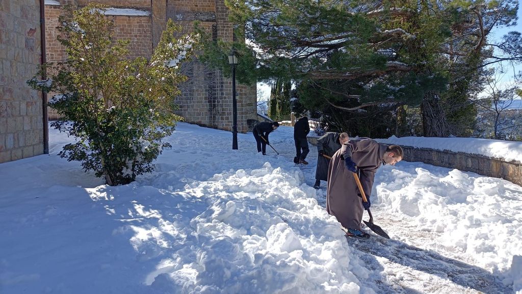 Monjes limpiando nieve