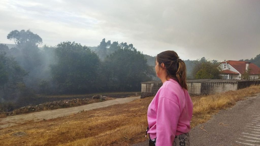 Vecina observa el humo provocado por el incendio de Crecente, en Pontevedra