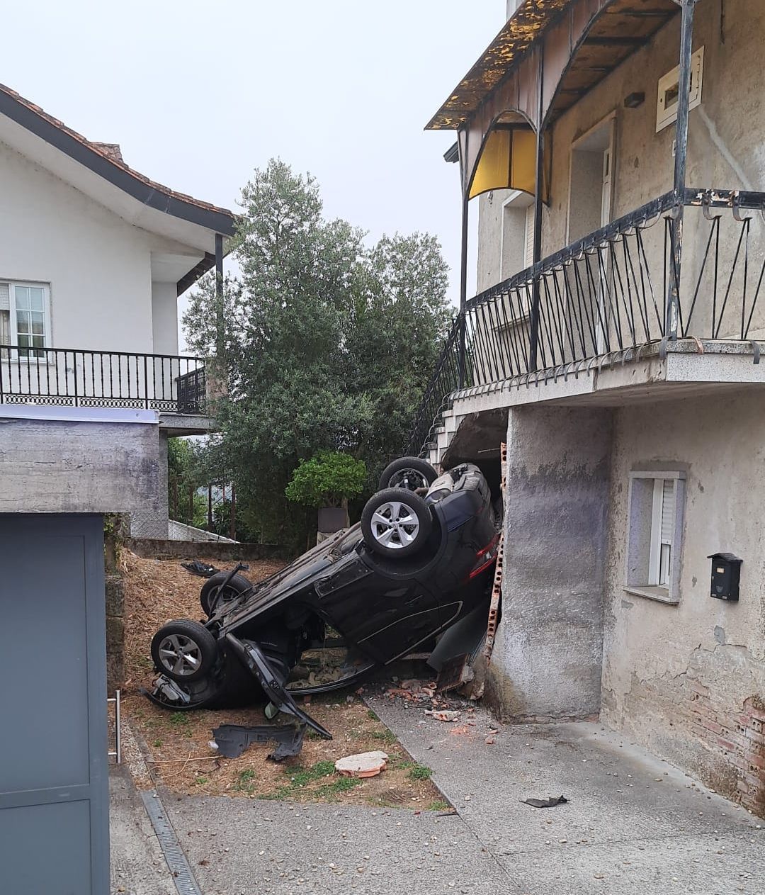 Coche volcado en el patio de una vivienda en Ourense