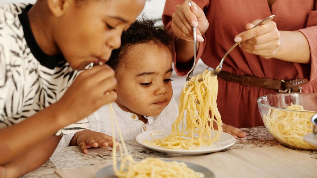 Niños comiendo espaguetis