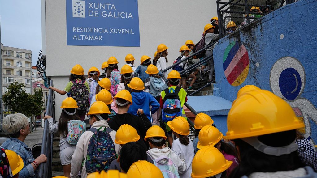 Imagen de niños accediendo al centro con cascos de protección