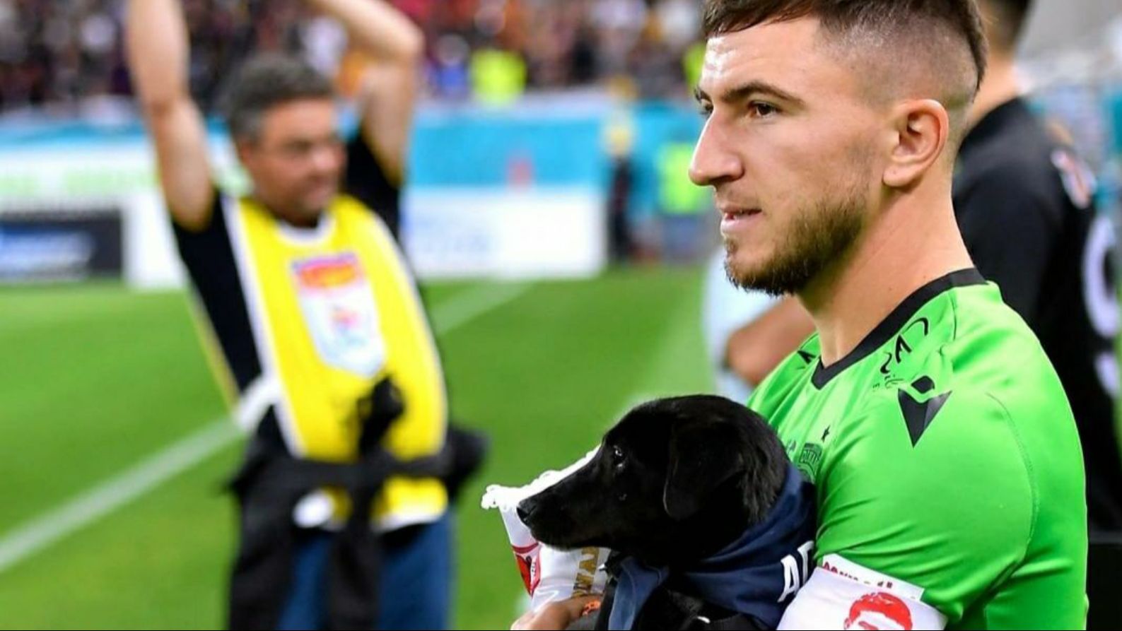 Jugador de Rumanía con un perro en brazos.
