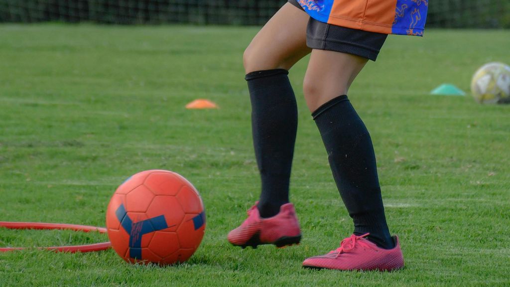 Menor entrenando en fútbol césped