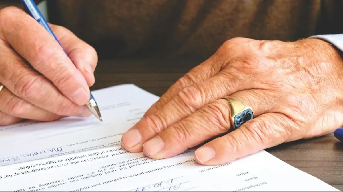 Un hombre firmando su herencia