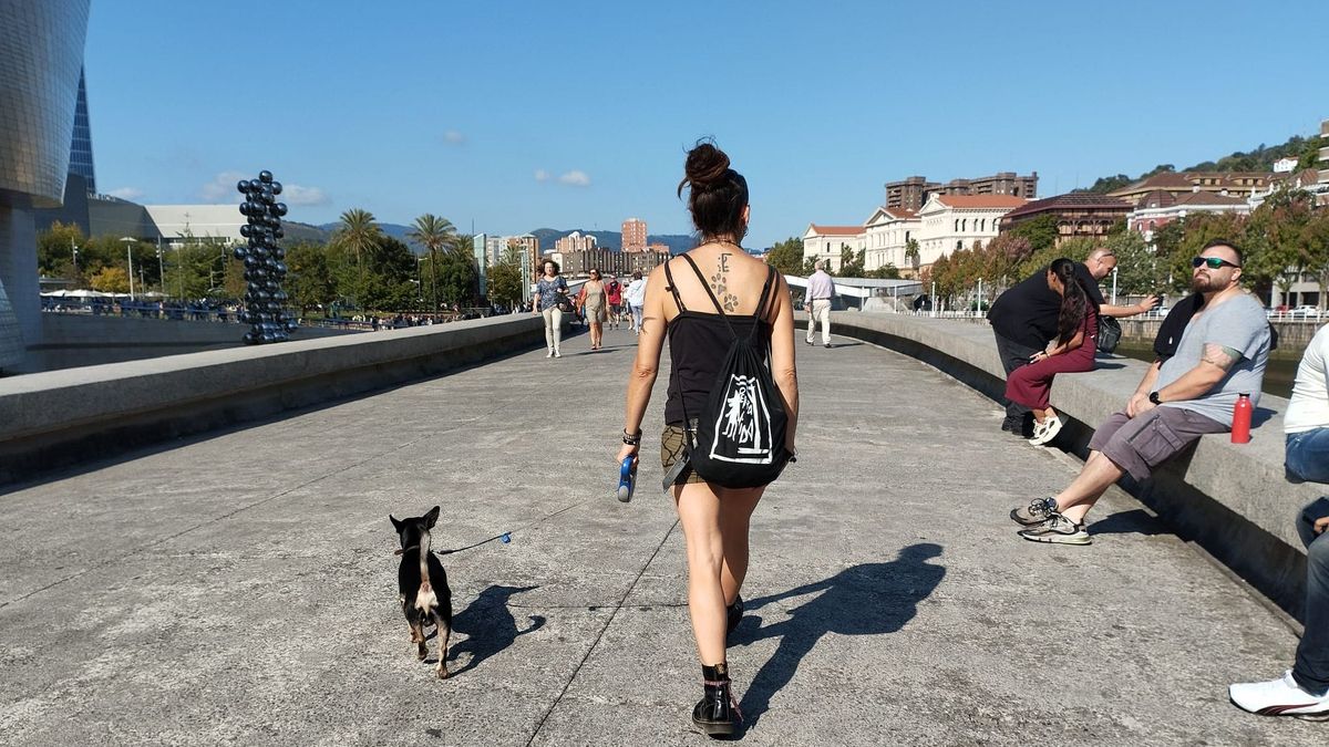 Una mujer pasea junto a su perro cerca de la ría de Bilbao