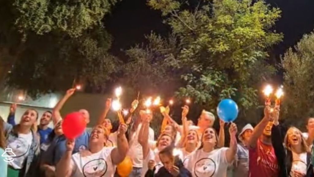 Amigos y familiares de Alba con globos y bengalas bajo la ventana