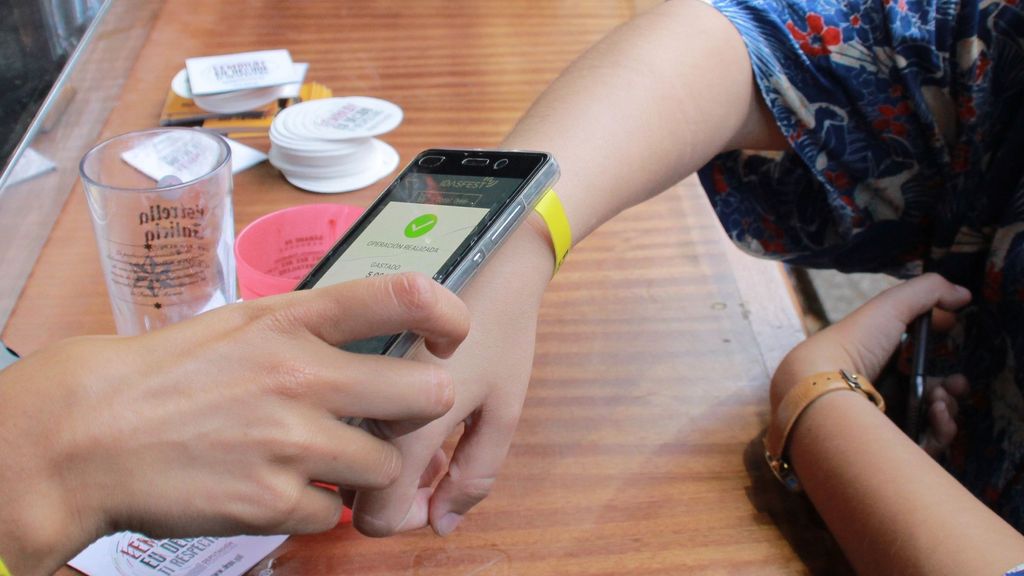 Una joven abona una consumisión con una pulsera 'cashless'