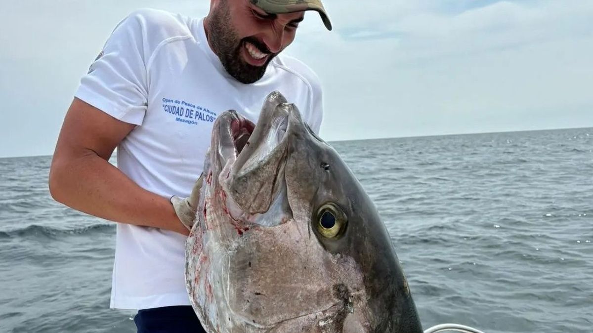 Uno de los pescadores intenta coger al ejemplar