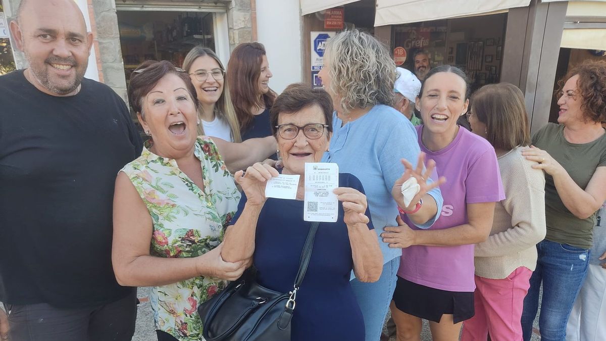 Tani y su hijo Bartolo posan felices a las cámaras con el boleto premiado en la mano