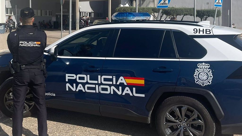 Agente de la Policía Nacional junto a su vehículo