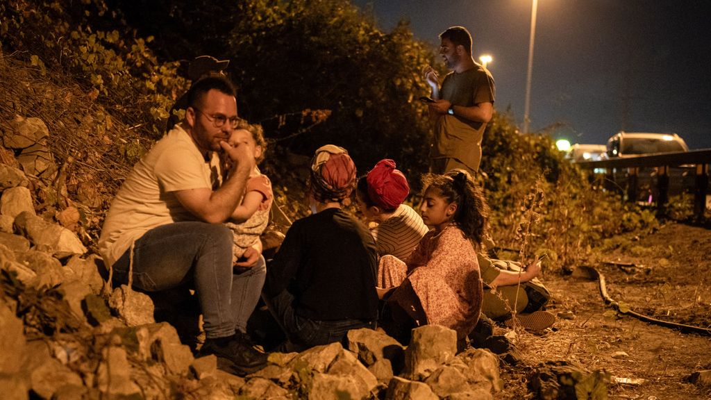 Varias personas se ponen a cubierto en un arcén de Tel Aviv, durante un aviso de llegada de misiles lanzados desde Irán