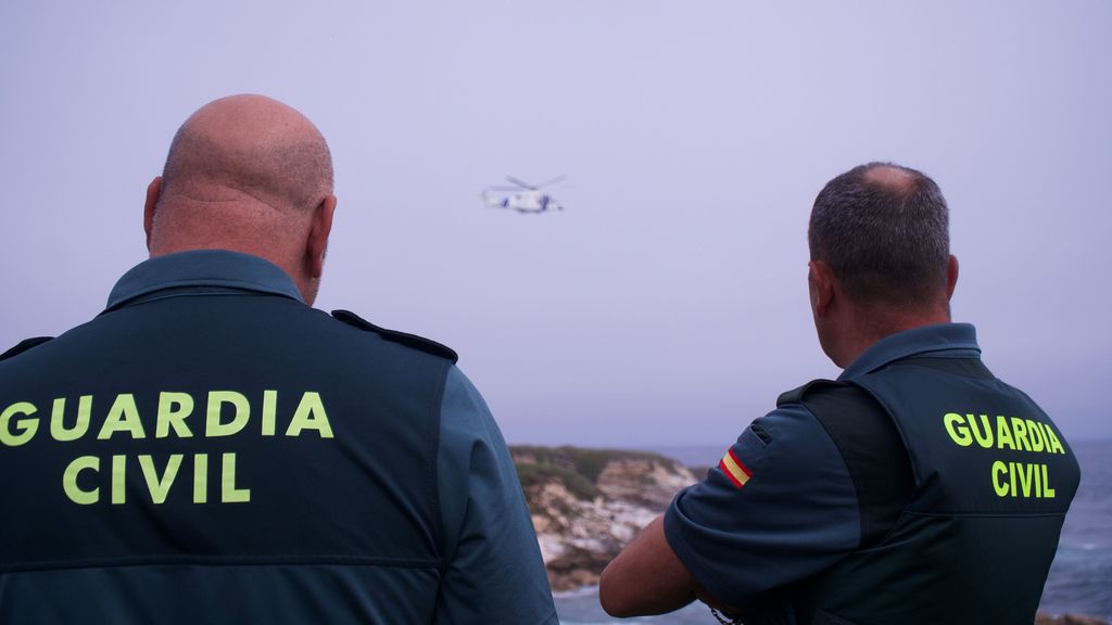 Imágenes de archivo de dos agentes de la Guardia Civil que observan las labores de rescate de un helicóptero de salvamento