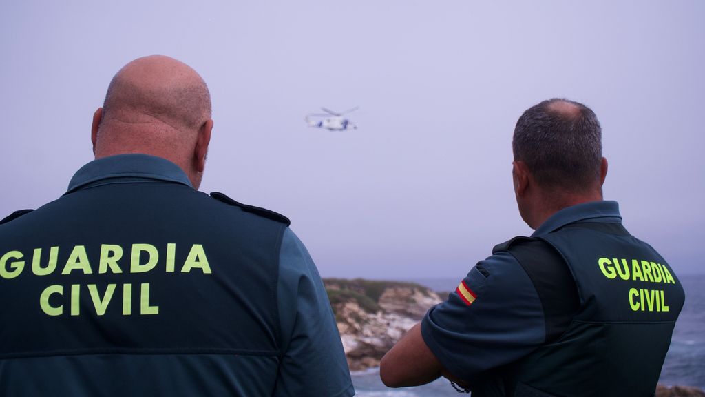 Dos agentes de la Guardia Civil de espaldas frente al mar