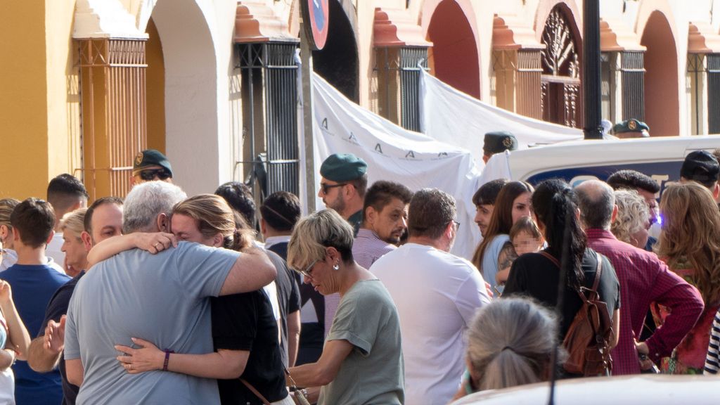 Familiares y amigos en la entrada a la vivienda donde cuatro personas han muerto en Guillena