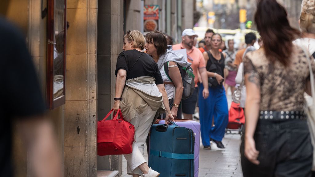 Varios turistas con maletas en el centro de Barcelona