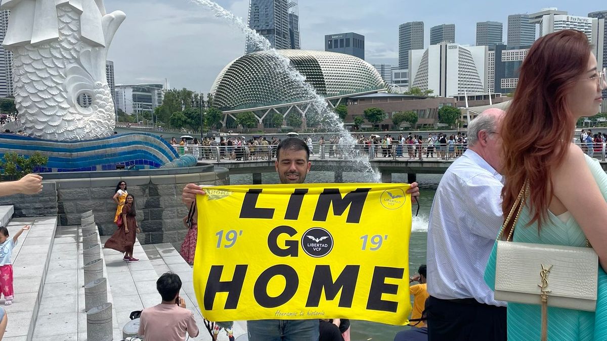 Daniel Cuesta mostrando públicamente en Singapur su pancarta contra Peter Lim.