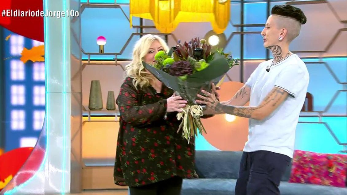 Deborah le entrega un ramo de flores a su madre