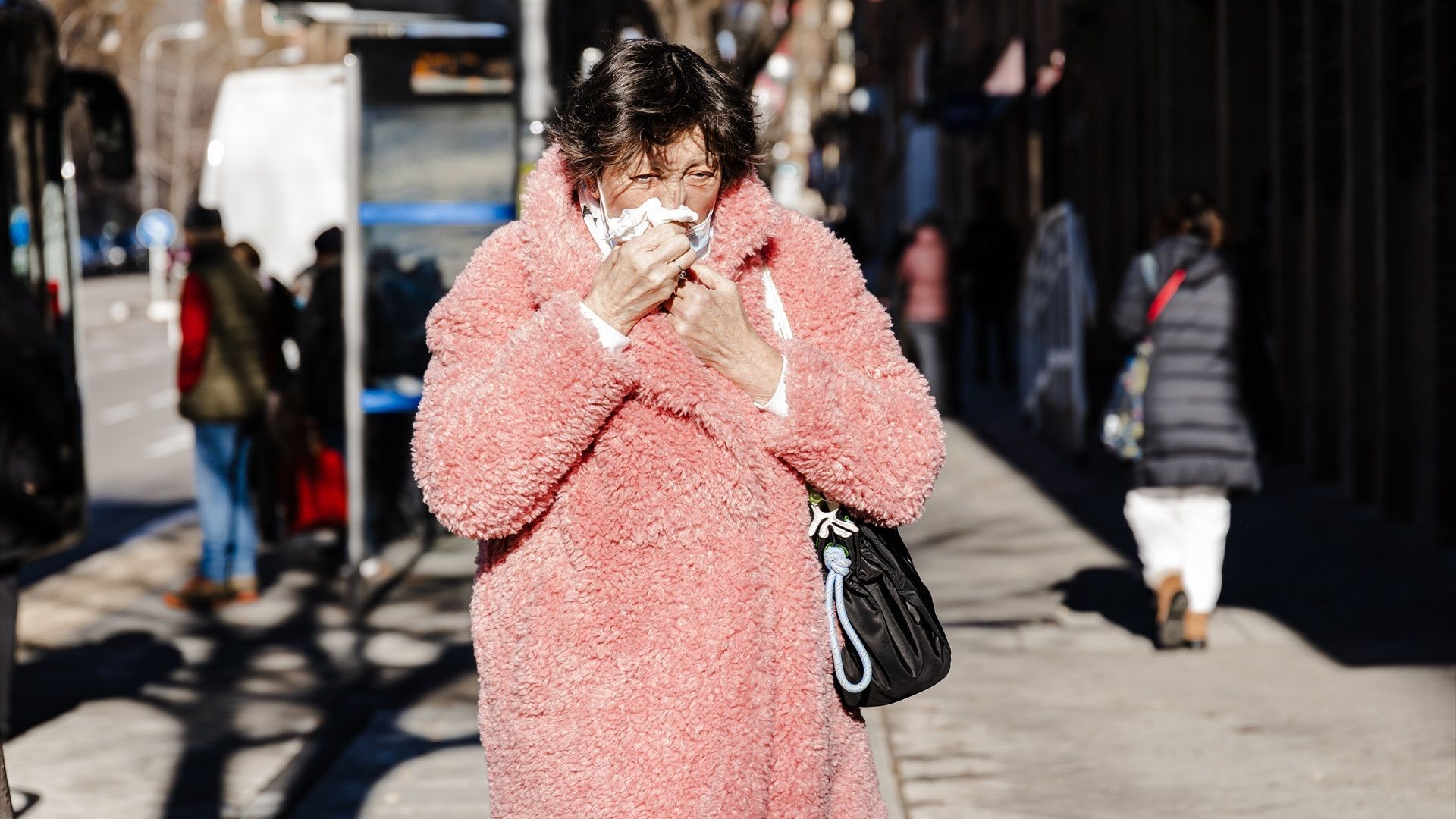 Una mujer con cogestión nasal pasea por una calle de Madrid. Foto de archivo.