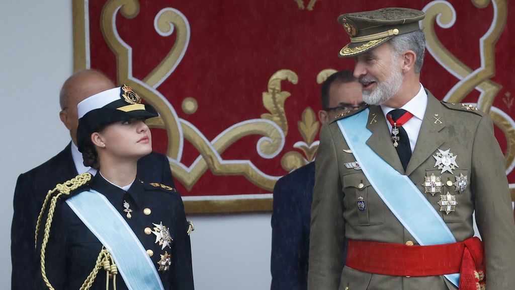 El rey Felipe conversa con la princesa Leonor (i) durante el desfile por el Día de la Fiesta Nacional en Madrid