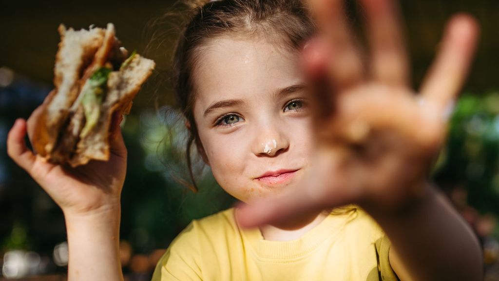 Niña comiendo hamburguesa premium