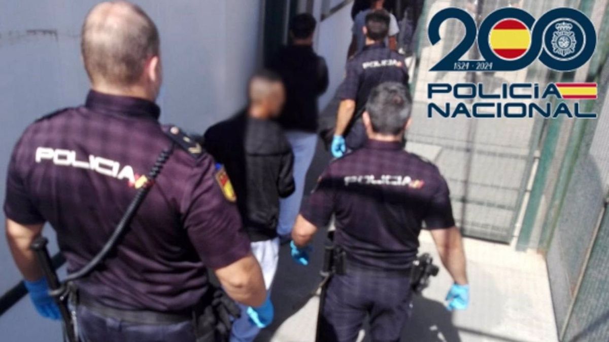 Agentes de Policía junto al detenido tras la muerte de un hombre hallado en una patera con destino Almería