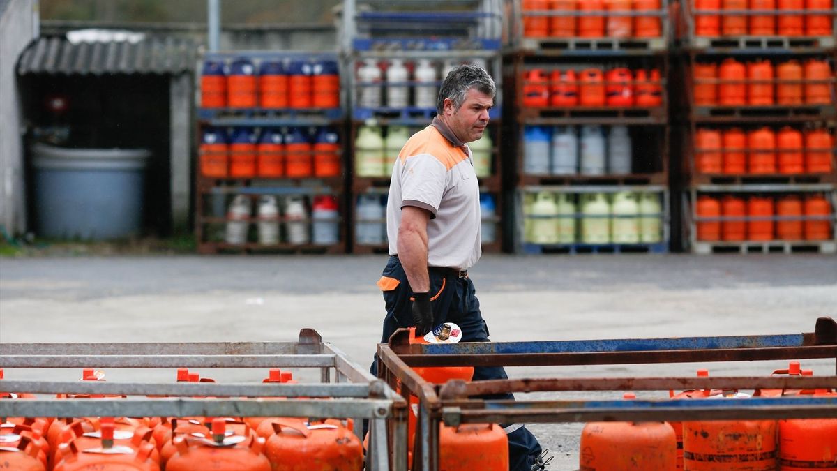 Un repartidor de bombonas de butano carga con una bombona en Lugo (Galicia).