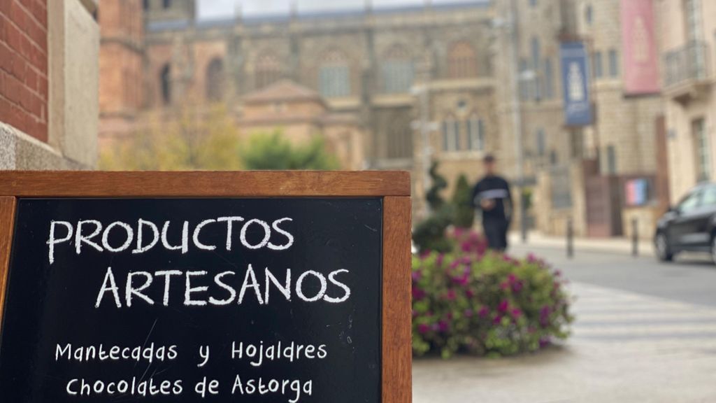 La catedral de Astorga, al fondo, con un cartel de sus reclamos culinarios