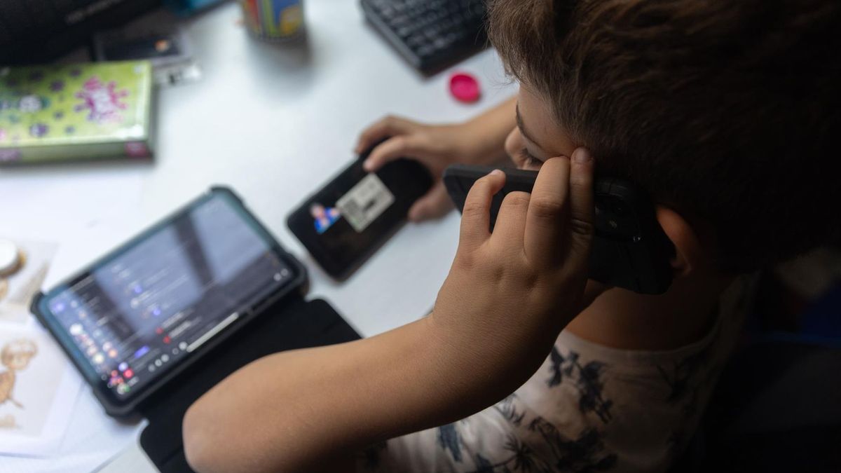 Un niño utiliza un móvil y una tablet