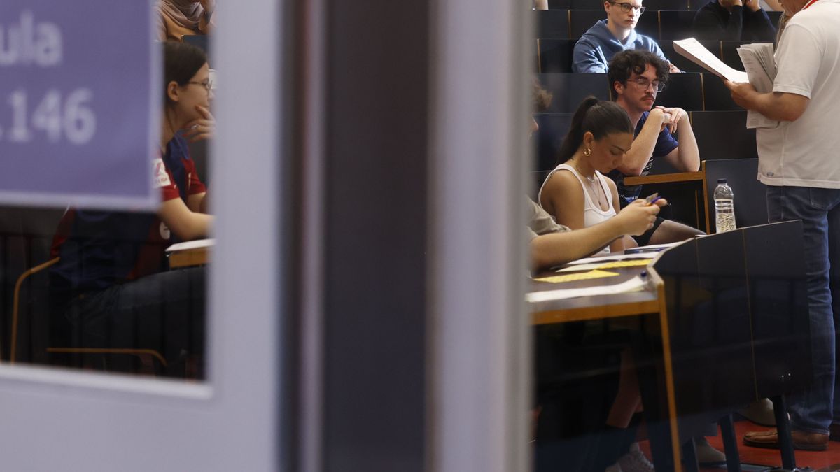 Estudiantes escuchan a un profesor, ajeno a esta información, en un aula universitaria.