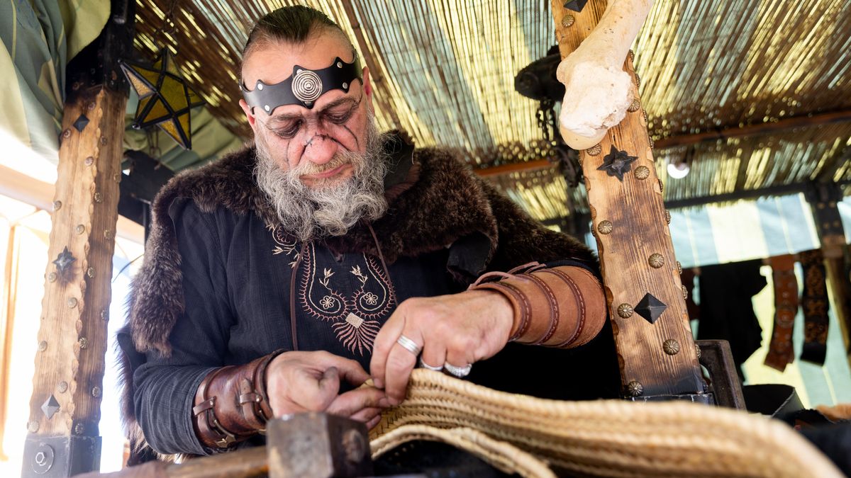 Un hombre vestido de época trabaja en un puesto durante una Feria Medieval celebrada en Madrid