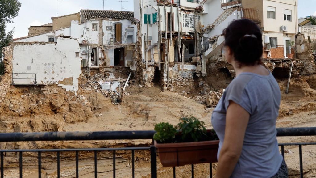 Una mujer observa varias casas dañadas en Chiva tras la DANA