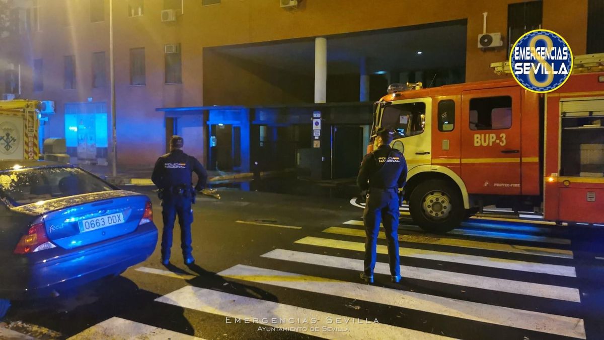 Operativo de Bomberos y Policía en un incendio en el parking subterráneo de un bloque de pisos en Sevilla.