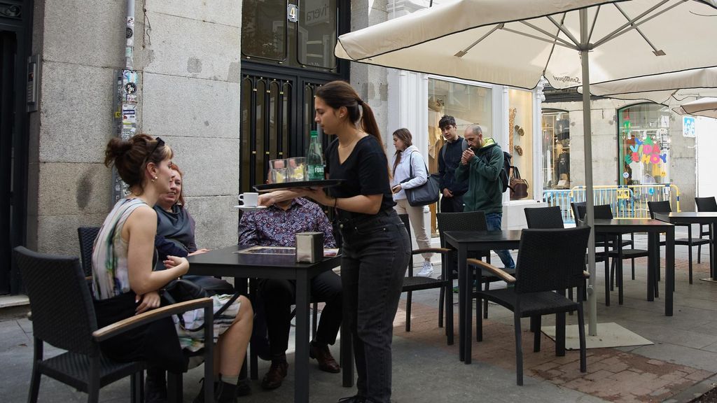 Archivo - Una camarera atendiendo las mesas de un bar